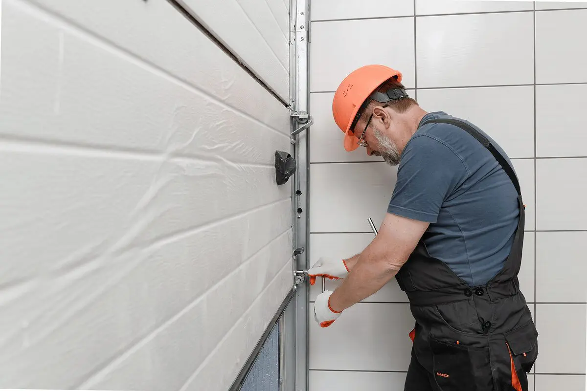 Worker fixing a garage door mechanism.