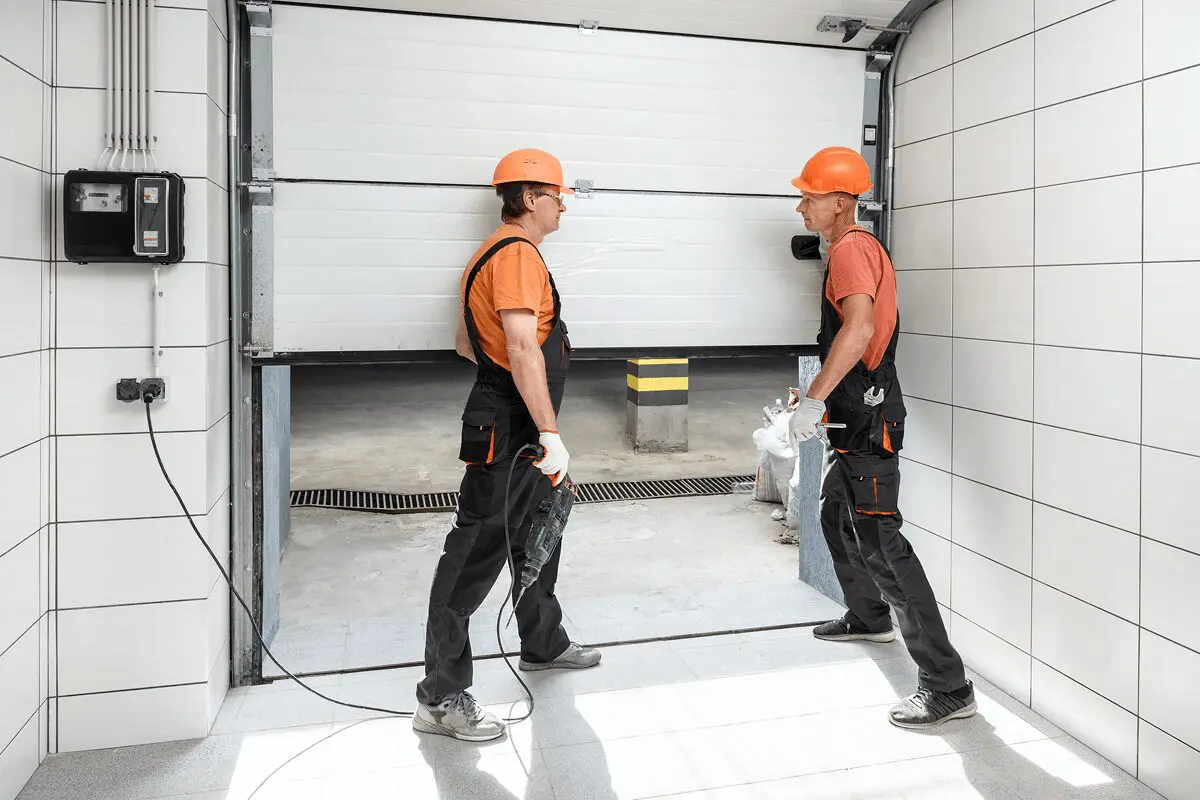 Workers installing a garage door together.