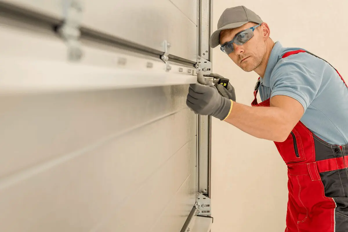 Worker fixing a garage door mechanism.